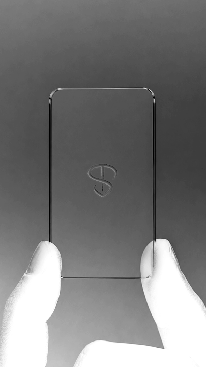 Stichora brand film — a glass phone etched with the Stichora monogram, held in gloved hands